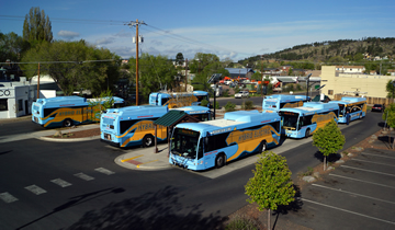 A group of buses parked on a street.